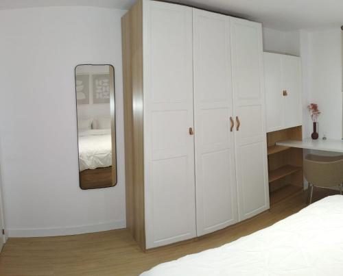 1 dormitorio con armarios blancos y espejo en Apartamentos Franchy C derecho, en Telde