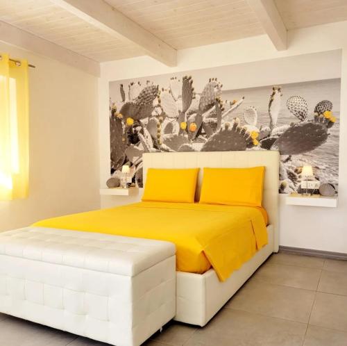 a bedroom with a white bed with yellow sheets at Casa del Sole Irgoli in Irgoli