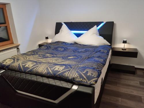 a bedroom with a bed with a blue and gold blanket at Ferienwohnung "Seaside Deluxe" in Lindenberg im Allgäu