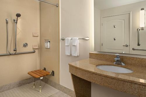 a bathroom with a sink and a shower at Holiday Inn Hotel & Suites Maple Grove Northwest Minneapolis-Arbor Lakes, an IHG Hotel in Maple Grove