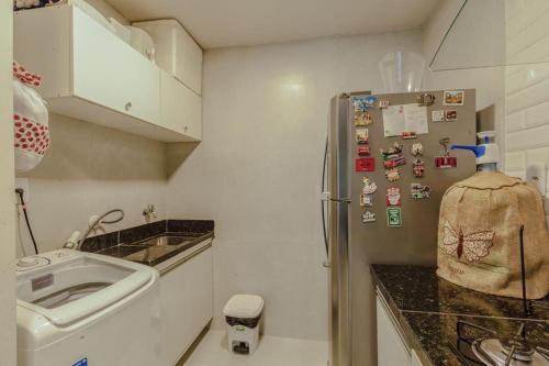 a kitchen with a refrigerator with magnets on it at Casa pé na areia no Tree Bies in Subaúma