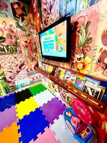 a room with a tv and a colorful wall at B12 Casa em Maresias condomínio a 50 metros da praia in Maresias