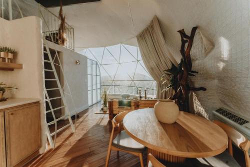 a room with a table and chairs and a window at Ona Geo Dome At El Mstico in Nogal