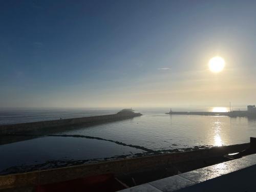 a misty sunrise over a body of water at Art riad au bord de la mer 2 in El Jadida