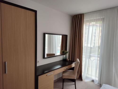 a bedroom with a desk with a mirror and a window at Modern 2BDRM in 5* Resort & pool in Sandanski