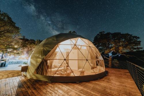 a large dome tent on a deck at night at Ona Geo Dome At El Mstico in Nogal