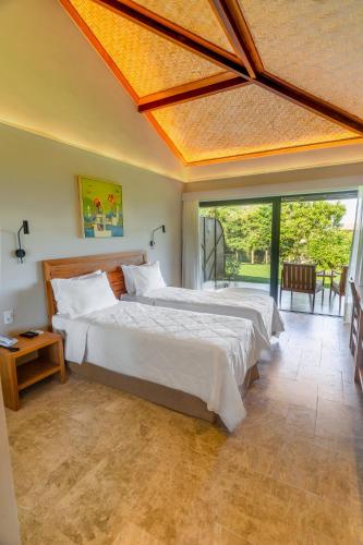 a bedroom with two beds and a large window at Buzios Espiritualidade Hotel in Búzios
