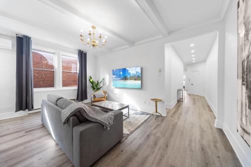 a living room with a couch and a chandelier at Modern and cozy 4 bedrooms sleep 12 in Montréal