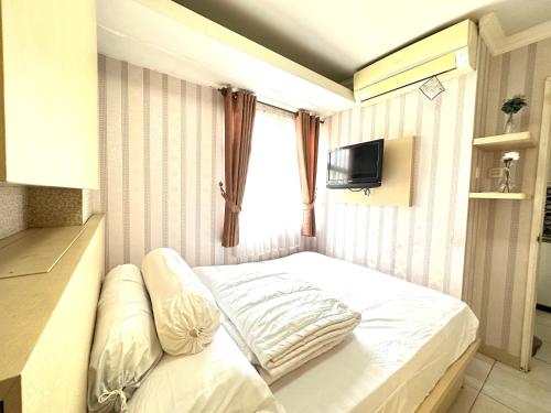 - un petit lit dans une chambre avec fenêtre dans l'établissement 2 Bedrooms Apartment Strategic Location Affordable for All, à Jakarta