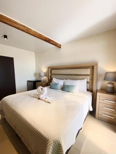 a bedroom with a bed with a stuffed animal on it at Paradise Surf Hotel in San Miguel