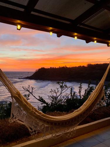 a hammock with a view of the ocean at sunset at Paradise Surf Hotel in San Miguel