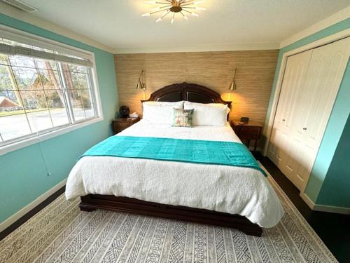 um quarto com uma cama grande e 2 janelas em The Blue House Bed and Breakfast em Lake Country