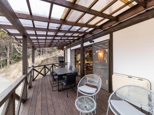a patio with a table and chairs on a deck at Kurokawa Mori No Kiki in Minamioguni
