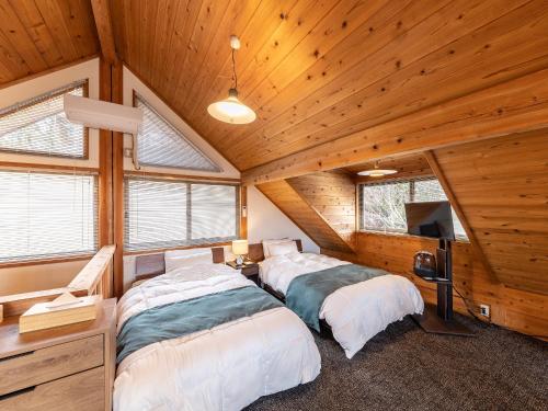 南小國的住宿－Kurokawa Mori No Kiki，配有木天花板的客房设有两张床。