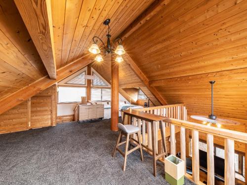a attic room with a wooden ceiling with a chandelier at Kurokawa Mori No Kiki in Minamioguni