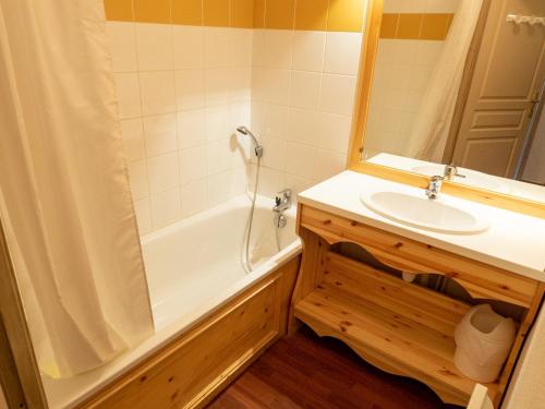 een badkamer met een wit bad en een wastafel bij Appartement Valfréjus, 2 pièces, 6 personnes - FR-1-468-65 in Valfréjus
