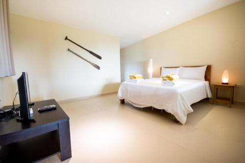 ボラカイにある2 Bedroom Loft with Jacuzzi - Hidden Paradiseのベッドルーム1室(ベッド1台、デスク、テレビ付)