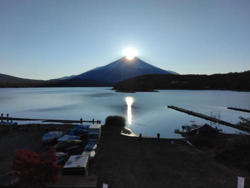 Tabist Lakeside in Fujinami Yamanakako في ياماناكاكو: اطلالة على بحيرة مع جبل في الخلفية