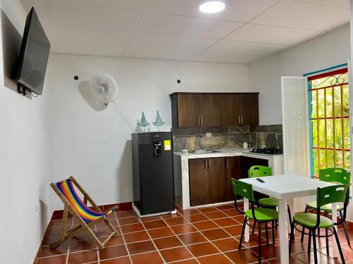 a kitchen with a refrigerator and a table and chairs at Apartaestudio Villa Mary-Aguachica in Aguachica