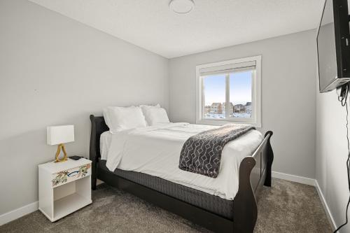 a bedroom with a bed and a window at Extra Large House with AC, Banff Access, Sleep 12, BBQ, 4 Bedrooms & 2 Sleeper Sofa Beds in Airdrie