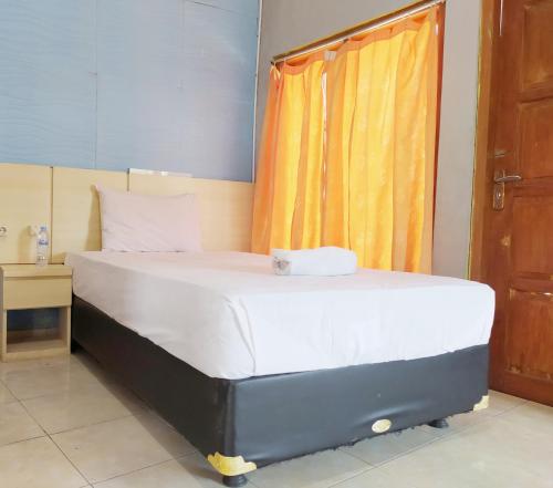 a large bed in a room with a window at RedDoorz at DeAmartaLoka Colomadu Solo in Tjolomadu