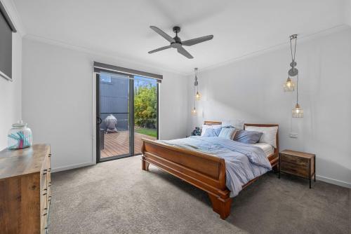 a bedroom with a bed and a ceiling fan at Sandy Feet Retreat in Inverloch