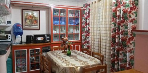 a kitchen with a table and a dining room at Charming Getaway @ The City of Pines in Baguio
