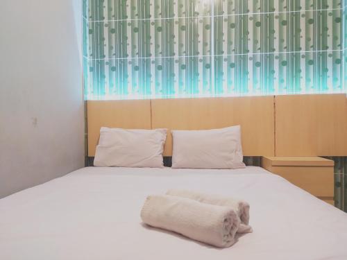 - une chambre avec un lit et 2 serviettes dans l'établissement RedDoorz at DeAmartaLoka Colomadu Solo, à Colomadu