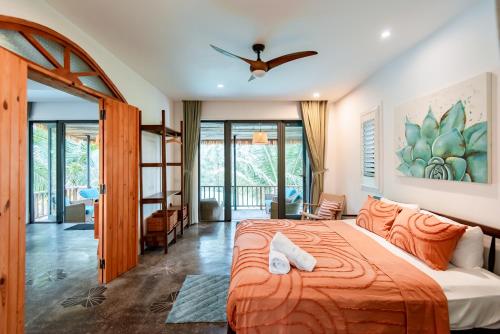 Salt Villa 3BR Oceanview An Bang Beach Hoi An في An Bàn: غرفة نوم بسرير ولحاف برتقالي
