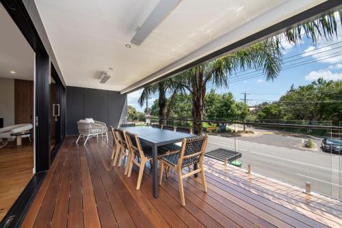 a dining room with a table and chairs on a deck at Sandringham Sunshine Escape in Sandringham