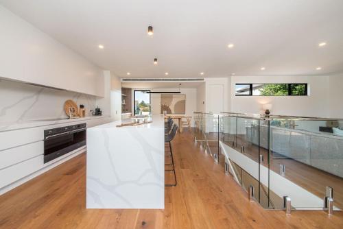 a kitchen with white countertops and glass railing at Sandringham Sunshine Escape in Sandringham