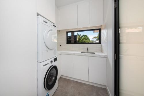 a laundry room with a washing machine and a sink at Sandringham Sunshine Escape in Sandringham