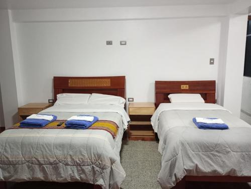 two beds in a room with towels on them at HOTEL SÚMAQ PUÑUY in Yungay