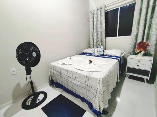 a bedroom with a bed with a fan and a window at Chalé Sol de Verão Macapá-Pi in Luis Correia