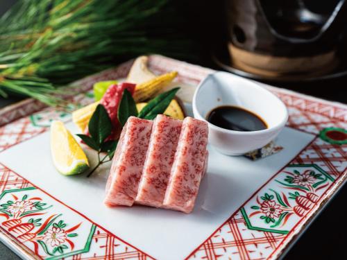 a plate with a piece of meat and a cup of coffee at Umino Ryotei Okinawa Nakamasou in Onna