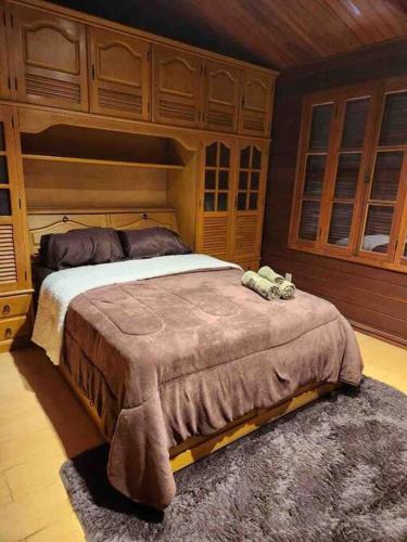 a bedroom with a large bed with wooden cabinets at Casa Monte Verde in Petrópolis