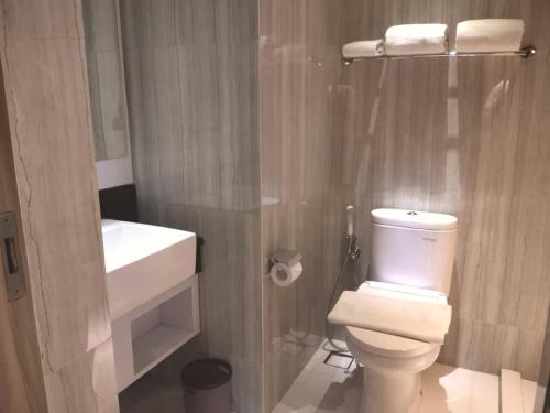 uma casa de banho com um WC branco e um lavatório. em Surabaya River View Hotel em Surabaia