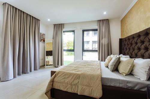 ein Schlafzimmer mit einem großen Bett und einem großen Fenster in der Unterkunft Incredible 2 Bedroom Space Available in Accra