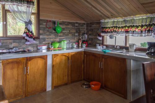 a kitchen with wooden cabinets and a counter top at Killary, Laguna de La Cocha in Pasto