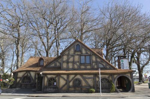an old house with a roof on a street at Maple Lodge Motel in Matamata