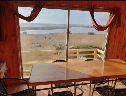 una mesa frente a una ventana con vistas en Cabañas la puntilla montaña río y mar, en San Antonio