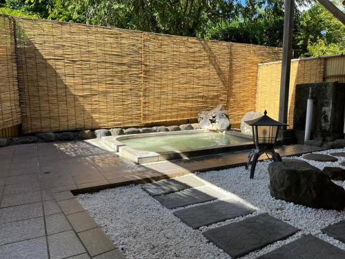 a cat sitting in a pool in a backyard at Fuji-Hakone Guest House in Hakone