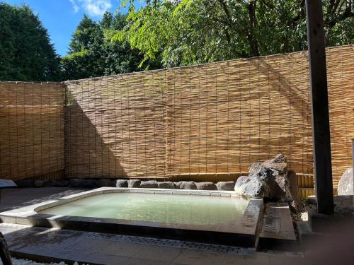 una pequeña piscina de agua frente a una pared de ladrillo en Fuji-Hakone Guest House en Hakone