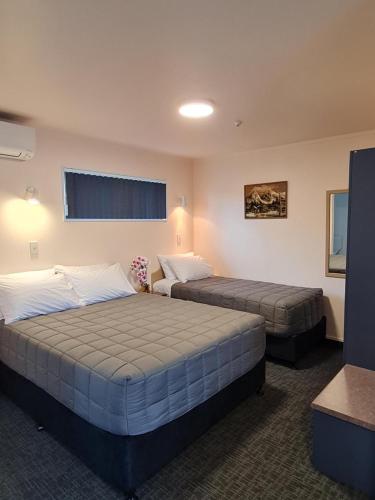 a hotel room with two beds and a window at Avenue Heights Motel in Whangarei