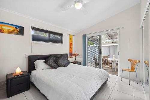a bedroom with a bed and a dining room at 28 Lorraine Avenue in Marcoola