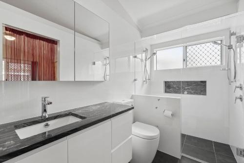 a white bathroom with a sink and a toilet at 28 Lorraine Avenue in Marcoola