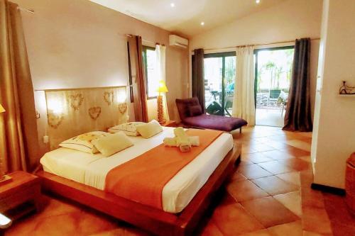- une chambre avec un lit avec un animal rembourré dans l'établissement Villa Akiba piscine chauffée & jacuzzi d'exception, à Saint-Pierre