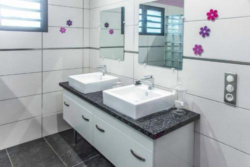 La salle de bains est pourvue de 2 lavabos et d'un miroir. dans l'établissement Villa Akiba piscine chauffée & jacuzzi d'exception, à Saint-Pierre