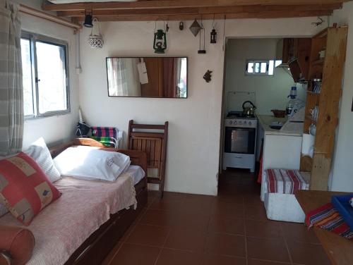 a small room with a bed and a kitchen at El Navegante in Cabo Polonio
