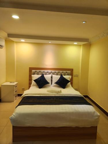 a bedroom with a large bed with blue pillows at Somato Hotel in Phnom Penh